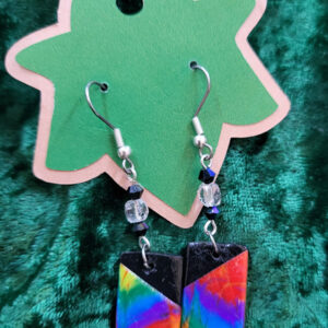Rectangular clay drops of a rainbow tie-dye with black upper inner corners, hanging from clear and black glass stations from silver earwires