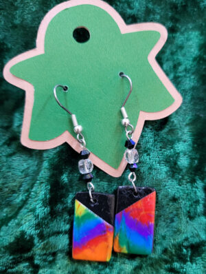 ArtDecoRainbow Rectangular clay drops of a rainbow tie-dye with black upper inner corners, hanging from clear and black glass stations from silver earwires