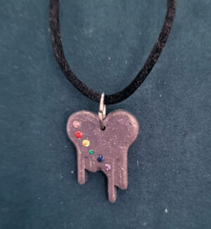 BleedingHeartRainbowNecklace A warm grey bleeding heart, accented along the left edge with a line of rainbow rhinestones